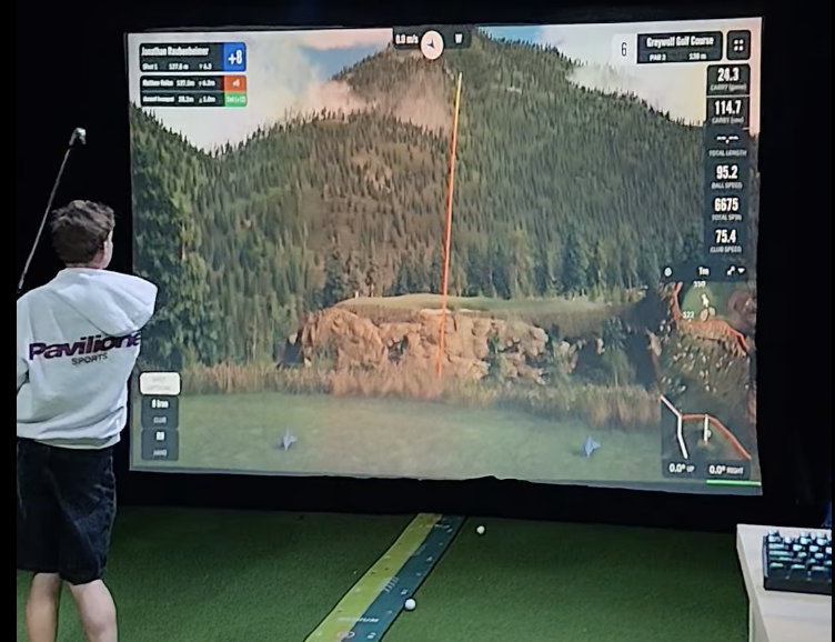 Player teeing off on the Graywolf Golf Course simulation at NextGen Golf Paarl